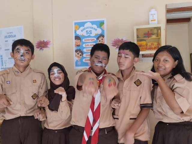 Siswa berseragam pramuka dengan lukisan wajah
