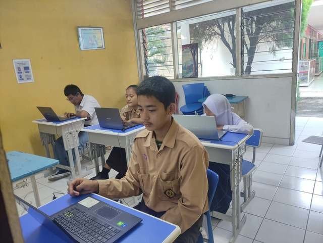 Siswa belajar mengetik sepuluh jari di laptop